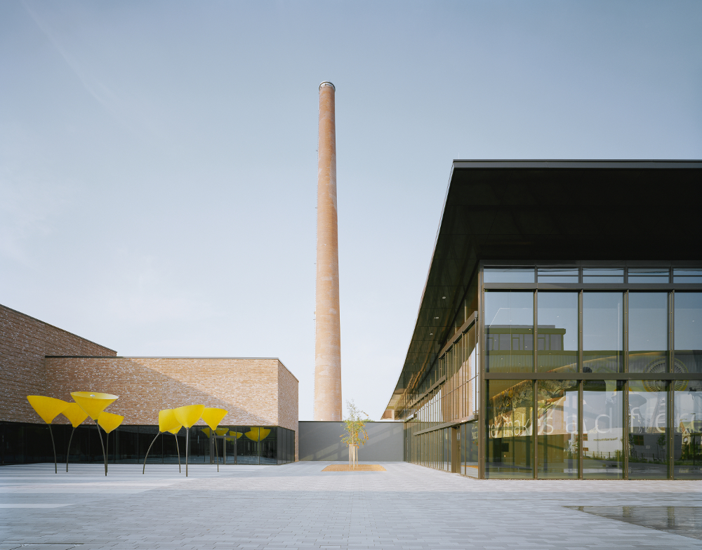 Kärcher Winnenden Tagansicht Vorplatz mit Viabizzuno Außenleuchte maxxi poppy in Form einer Mohnblume