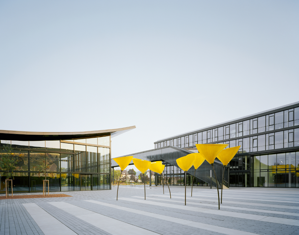 Kärcher Winnenden Tagansicht Vorplatz mit Viabizzuno Außenleuchte maxxi poppy in Form einer Mohnblume