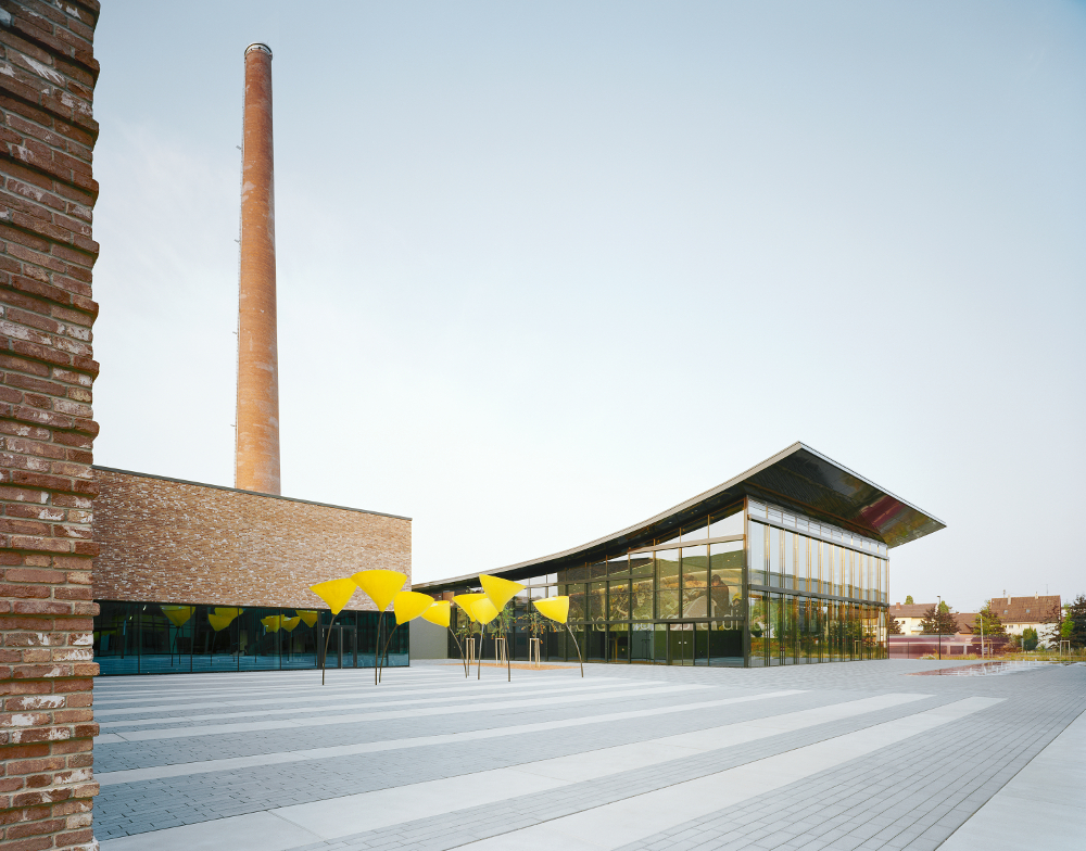 Kärcher Winnenden Tagansicht Vorplatz mit Viabizzuno Außenleuchte maxxi poppy in Form einer Mohnblume