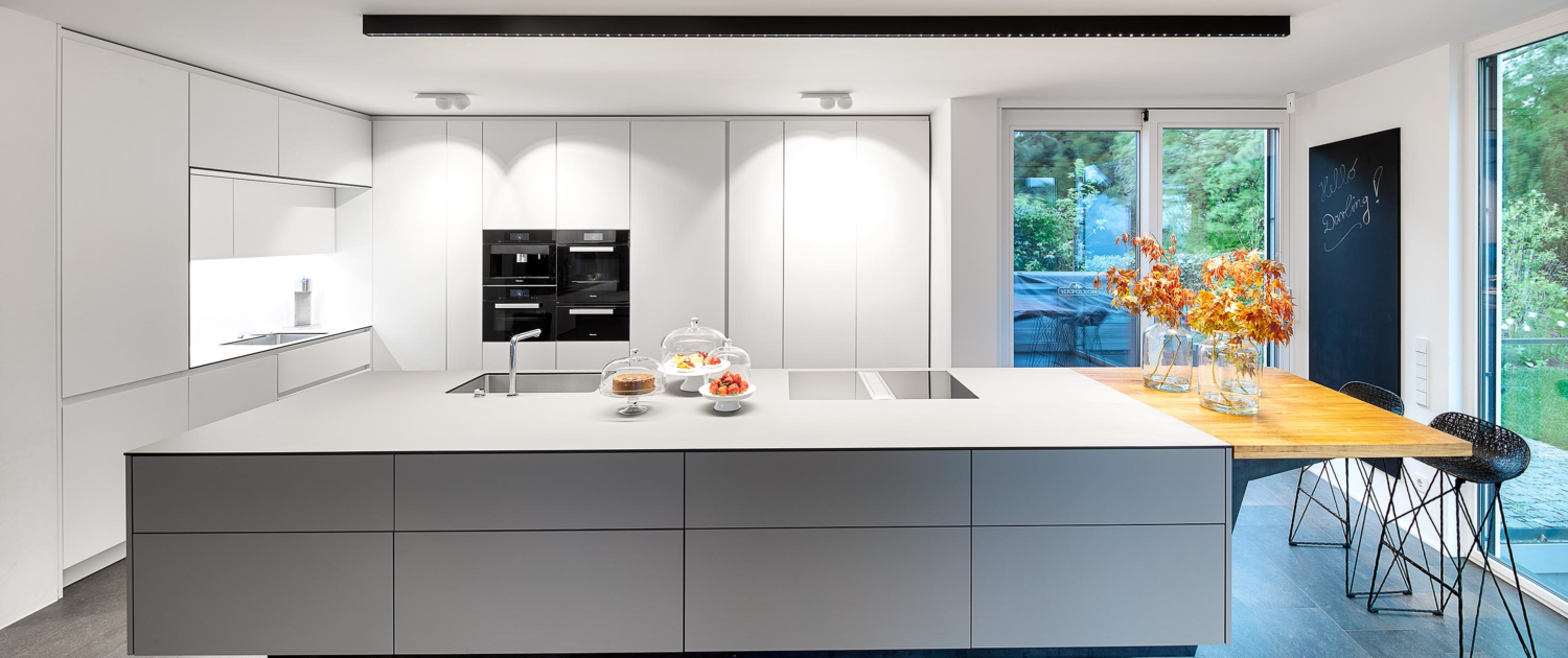 Perfekte Küchenbeleuchtung mit inVision Aufbauprofil von O/M Light über der Kücheninsel und Marbul Aufbauleuchten von Modular als Schrankbeleuchtung